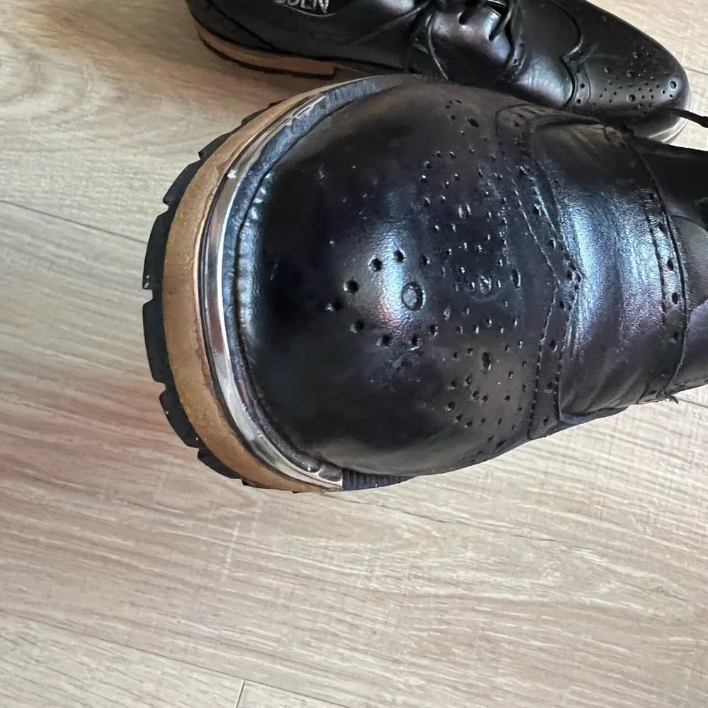 Men’s black leather wingtip shoes. Silver band at toe. Size 8 1/2